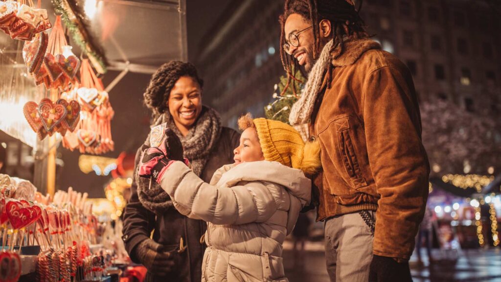A family enjoying Autism-Friendly Holidays in a festive outdoor event at night