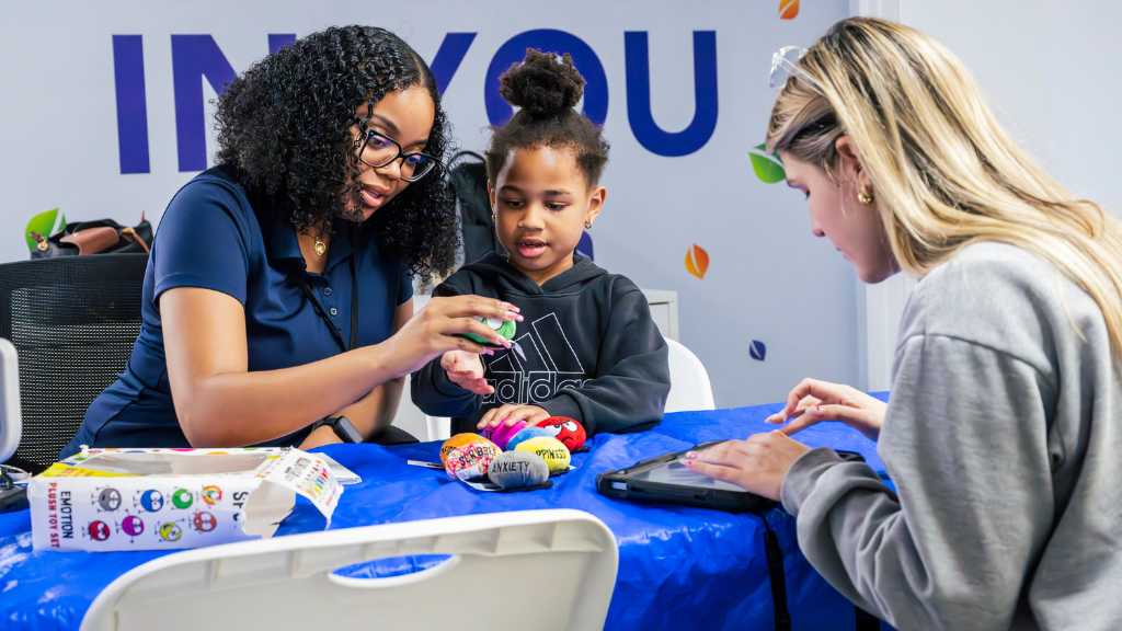 ABA provider and caregiver discussing therapy progress with child